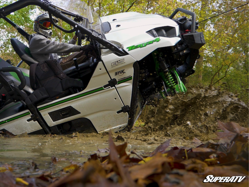 A Kawasaki Teryx burried up to the doors in mud and muck.