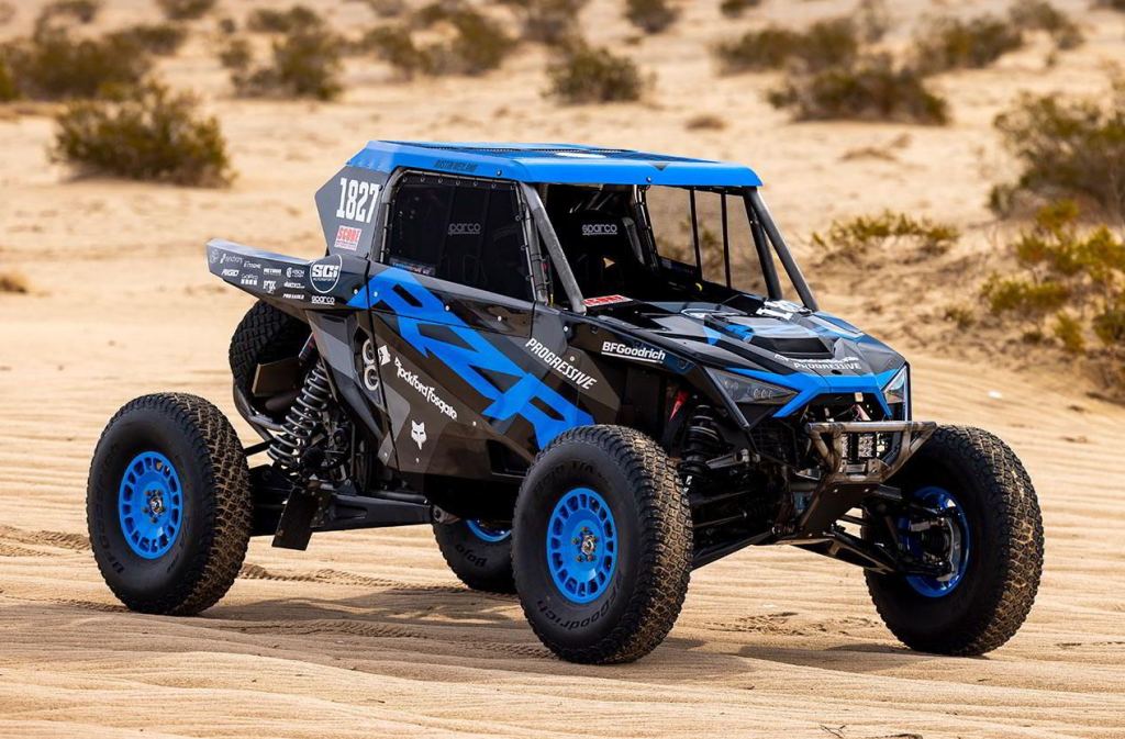 A Polaris RZR Pro R Factory parked on a sandy trail.