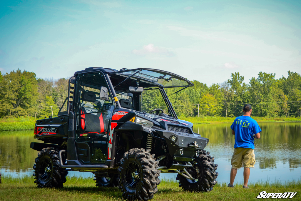 A Ranger XP 900 parked by a pond with a fisherman. 