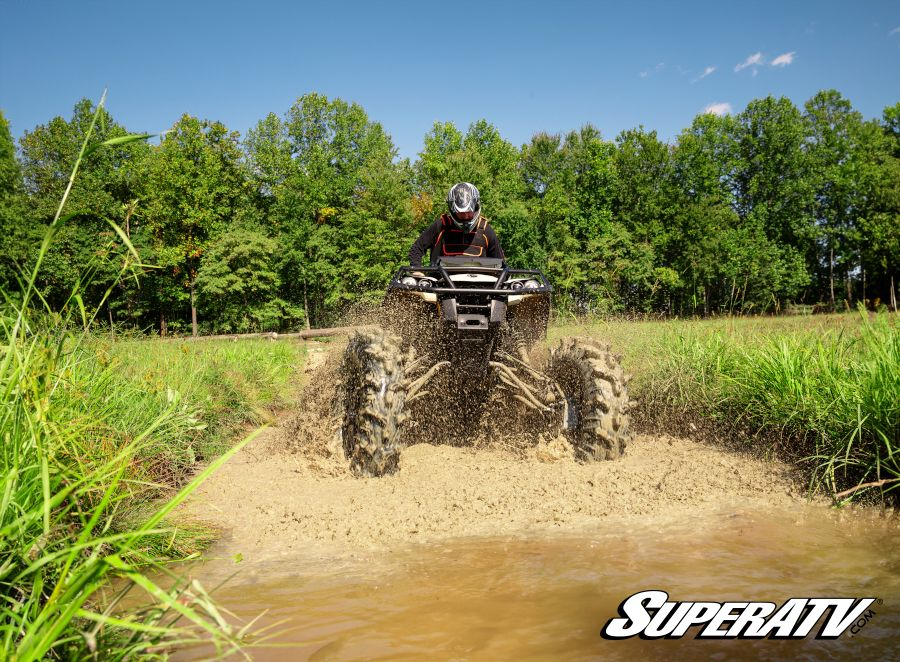 A Can-Am Outlander with GDP Portals installed being ridden through a mud pit.
