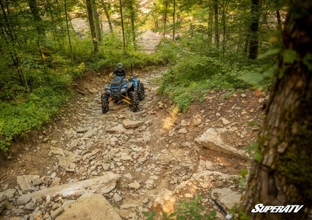 A rider on an ATV utilizing their winch.