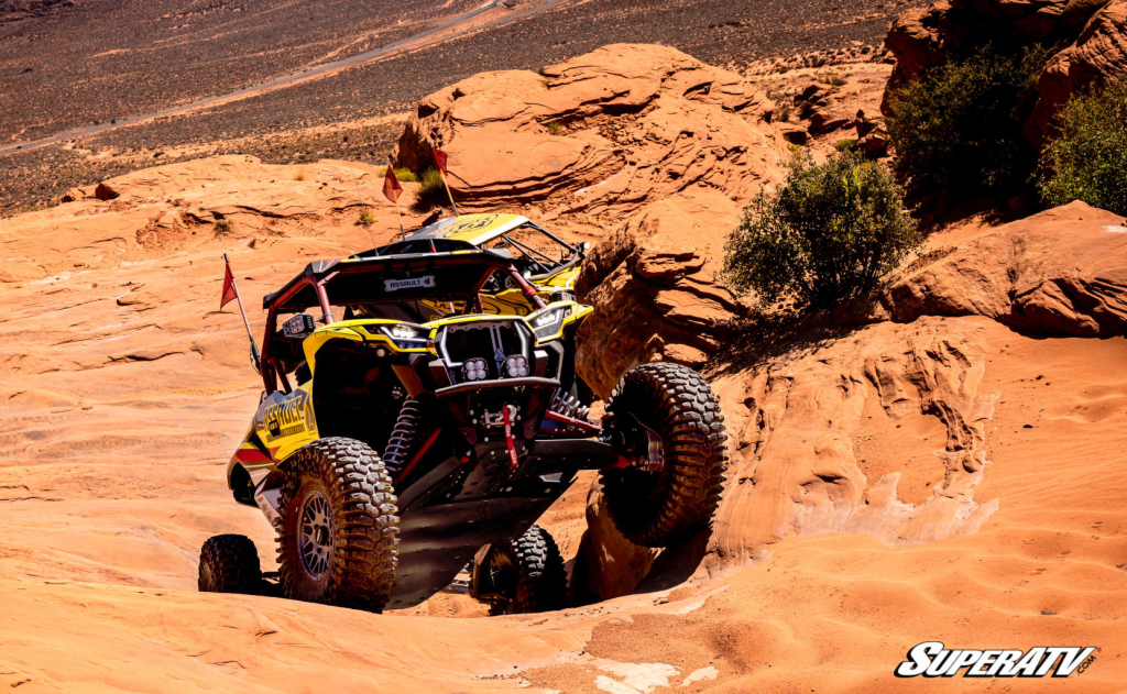 A Kawasaki KRX using the torque from a GDP Portal Gear Lift gear reduction to climb a challenging rock shelf.