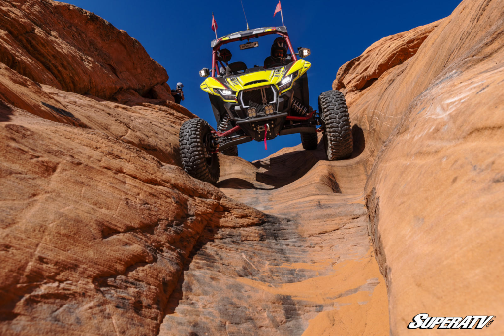 A Kawasaki KRX using a GDP Portal Gear Lift to crawl down a steep rock face.