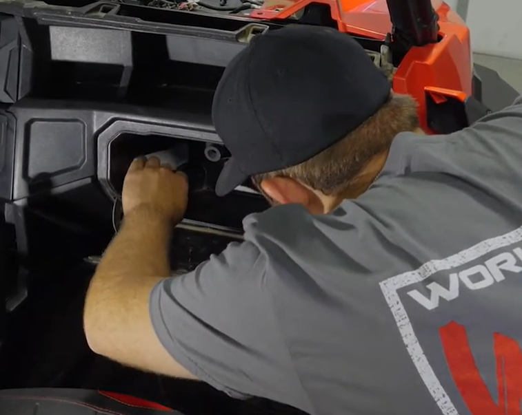 A mechanic preparing the glove box for a heater installation.