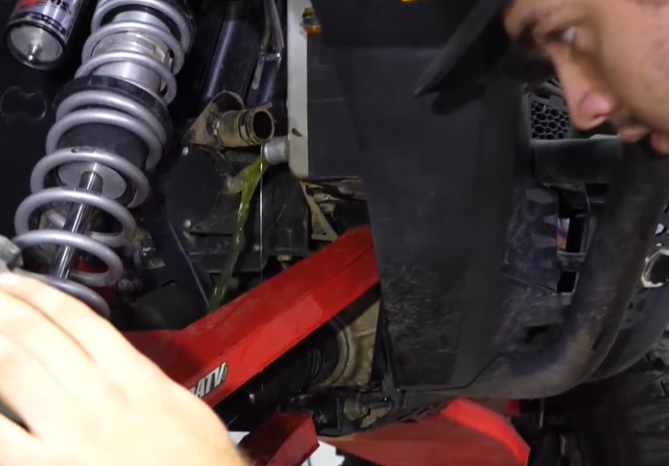 A mechanic bleeding the radiator on a Polaris General 1000. 