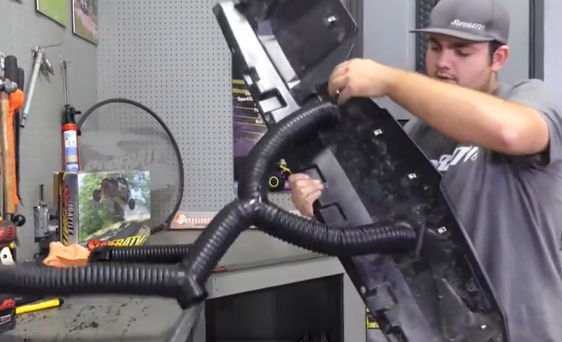 A mechanic installing upper dash vents for the UTV heater installation.