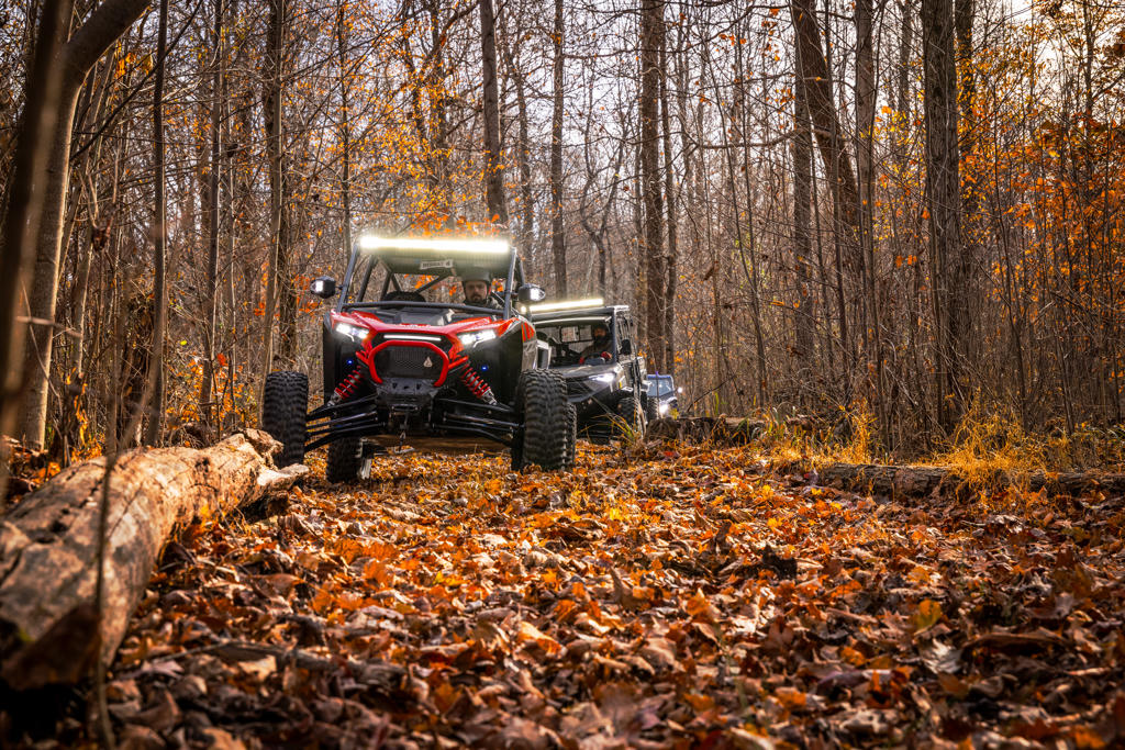 A convoy of UTVs in the woods playing music together