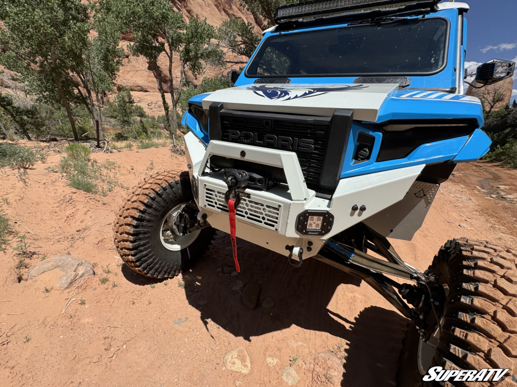 A customized Polaris Xpedition sporting a glass windshield with vents in the frame.