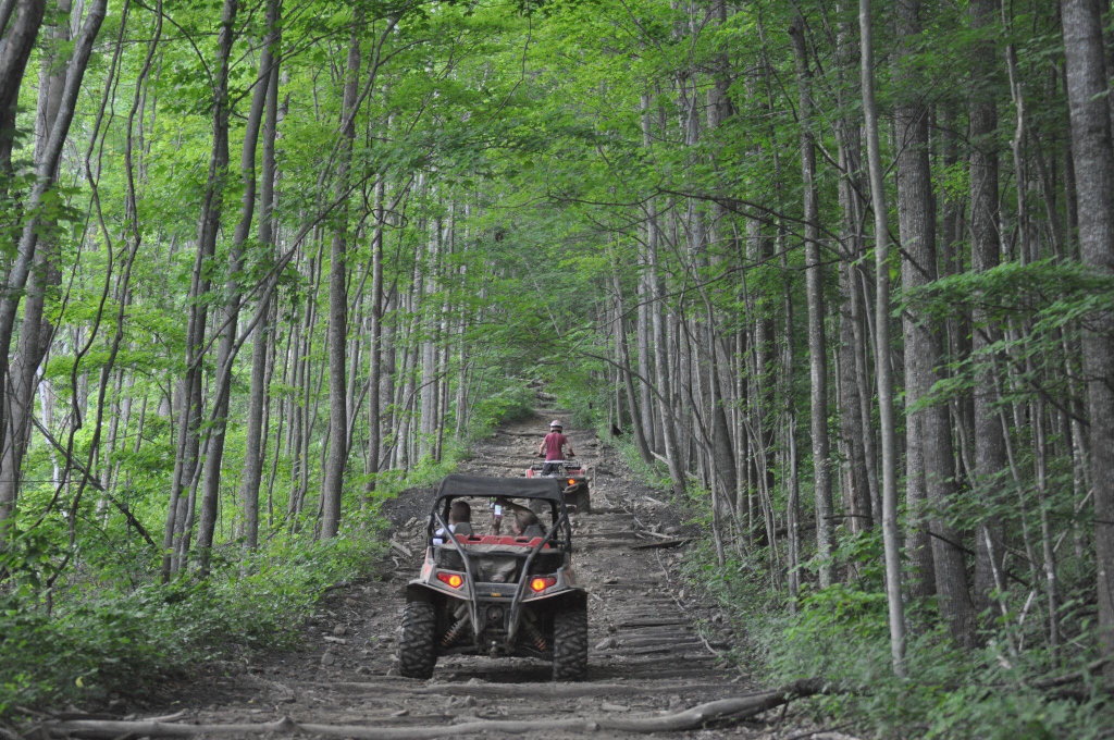A UTV and ATV riding through Windrock Park.