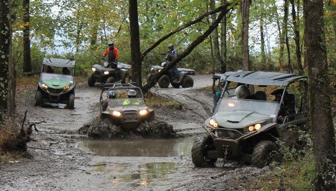 A group of ATVs and UTVs enjoying a mud hole in the woods of West Virginia