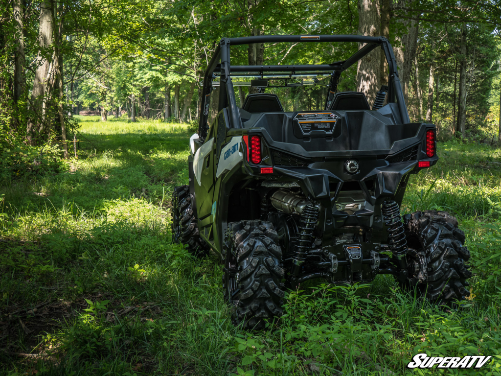 A Can-Am Maverick Trail on a wide grassy trail in the woods