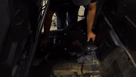The installer slides the seat converter into place in the back of the machine.