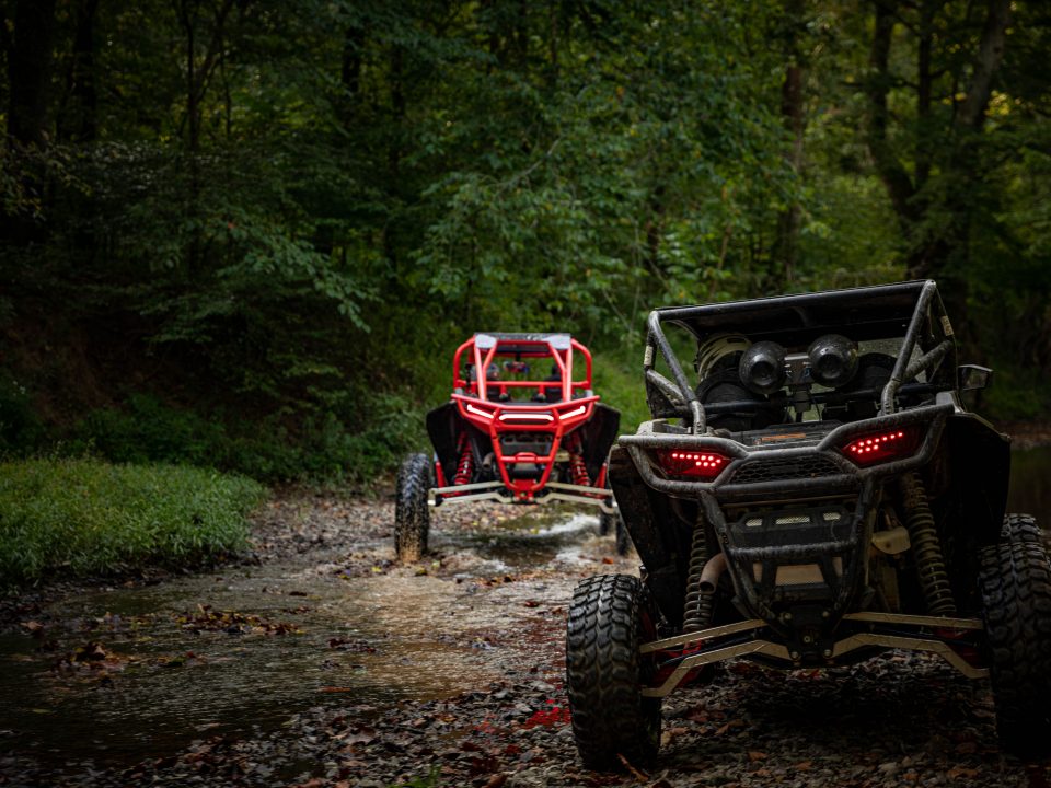 Rear end of Polaris RZR's riding down creek