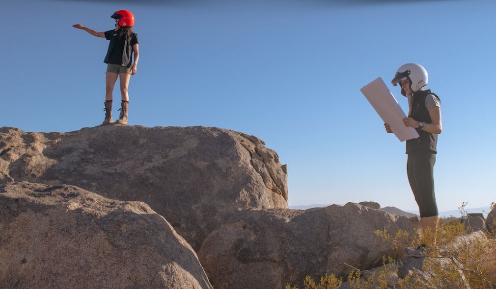 Man standing on rock looking at a map