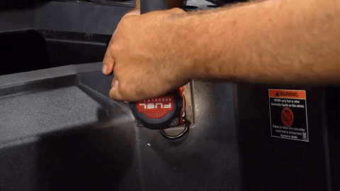 Brandon uses both hands and a drill to remove the hardware, all while holding onto a clip on the back.