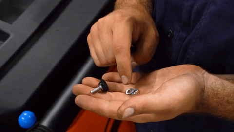 Brandon slides two washers onto a thumb screw.