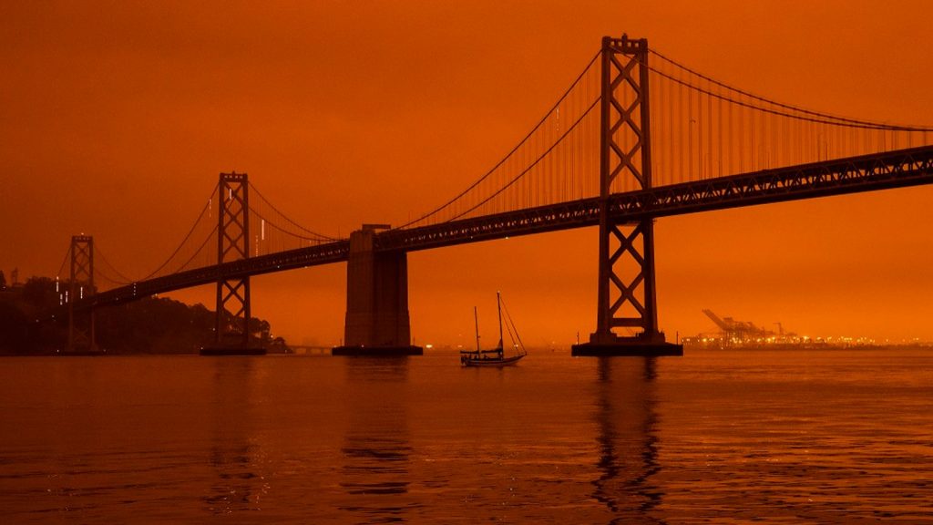 The Golden Gate Bridge is pictured against a hazy orange background