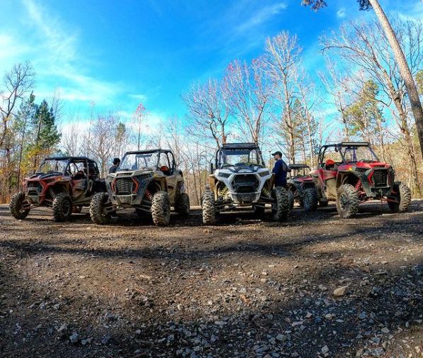 4 Polaris RZR's lined up and parked in woods