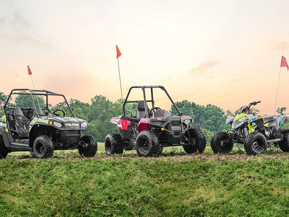 Youth ATVs and UTVs parked in a row